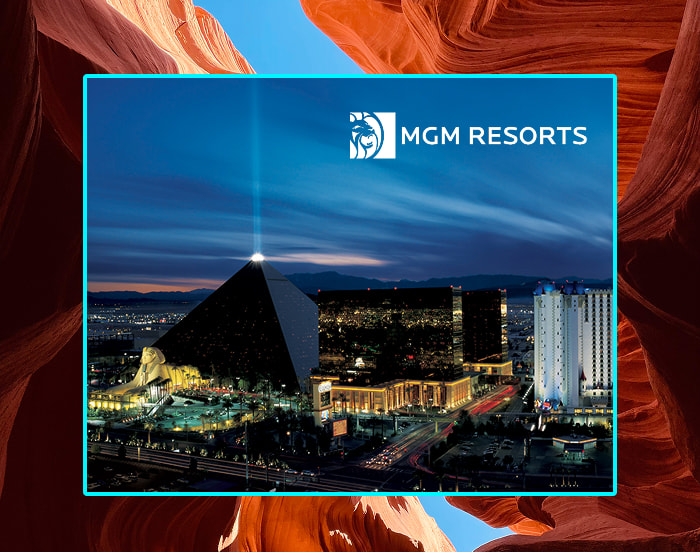 Promotional image showing an illuminated pyramid-shaped resort and surrounding hotels at night, framed by red canyon walls, with the MGM Resorts logo above.